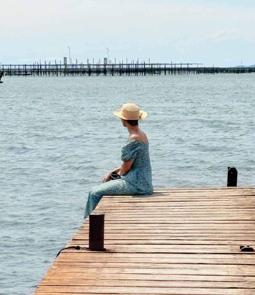 Personne au bord de l'eau se reconnectant à sa Joie intérieure grâce à l’instant présent